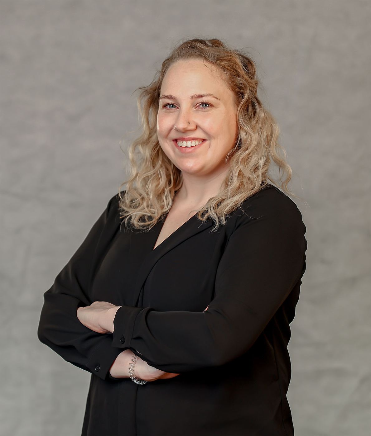 Professional headshot with crossed arms